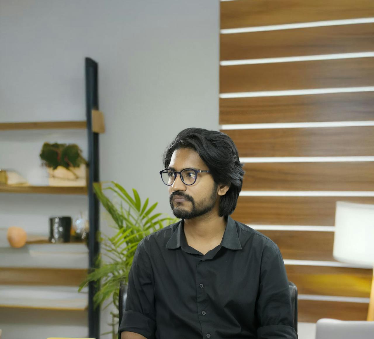 Portrait of a young professional in a modern office with wooden panel decor.